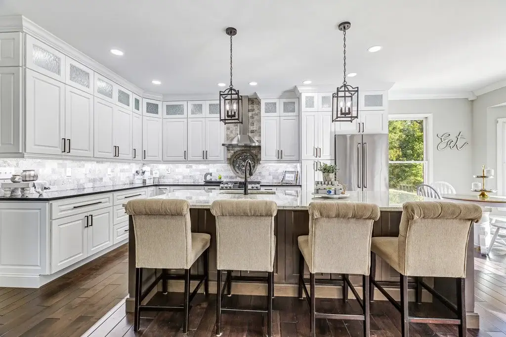 Bright completed kitchen with white cabinetry and a large island